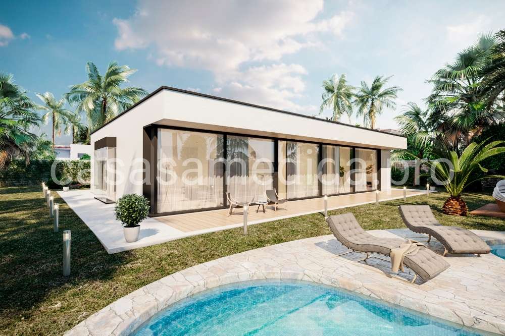 Casa prefabricada de alta eficiencia energética de forma cubica, tejado plano, ventanales grandes y fachada blanca.