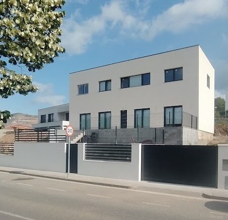 Casa cúbica de dos plantas con diseño moderno y grandes ventanales