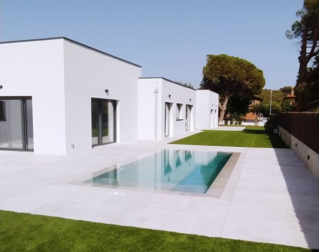 Casa prefabricada moderna de alta eficiencia energética, con piscina y jardín exterior.
