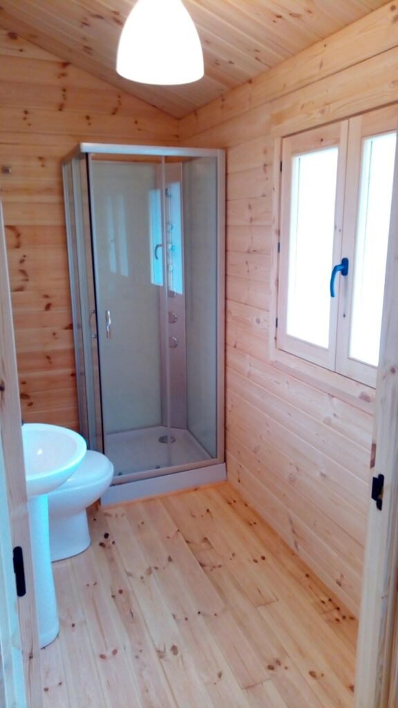 Baño con cabina de ducha en casa prefabricada rústica de madera de 70m2 en Sagunto