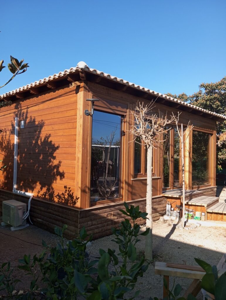 Exterior de casa prefabricada diáfana de madera en Murcia con grandes ventanales y porche