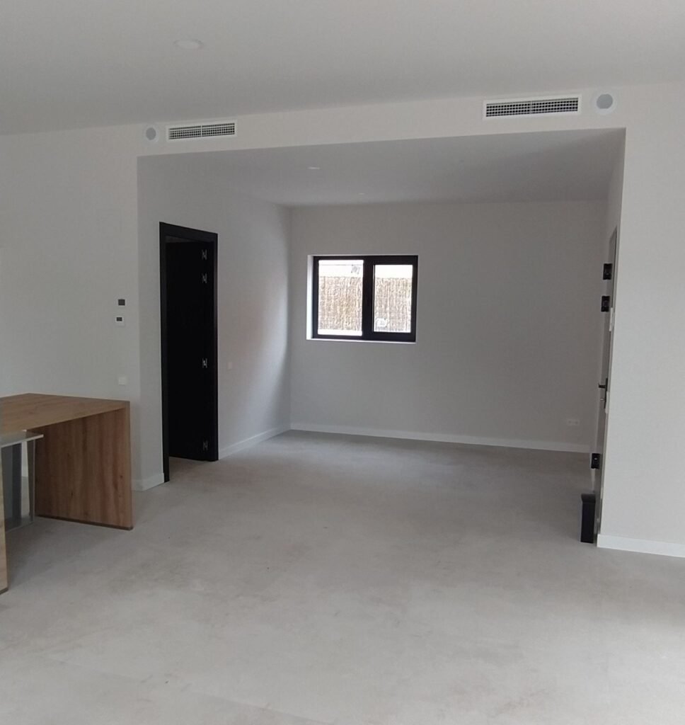 Salón amplio y luminoso en casa prefabricada moderna con ventana y suelo porcelánico