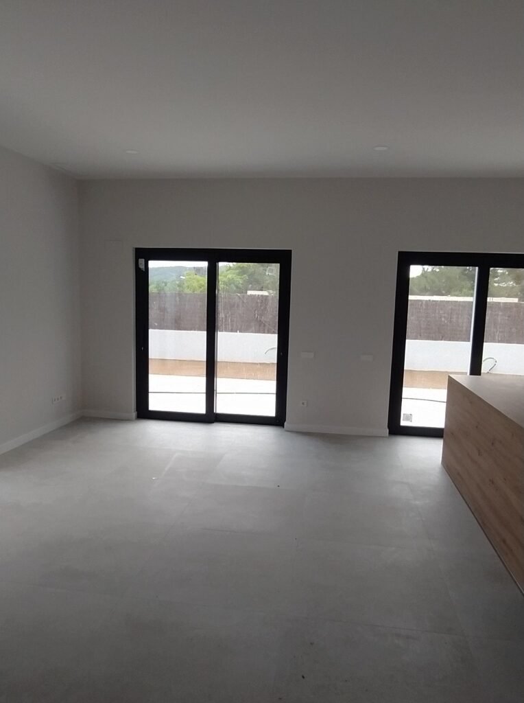Salón comedor con puertas correderas y salida a terraza en casa prefabricada moderna