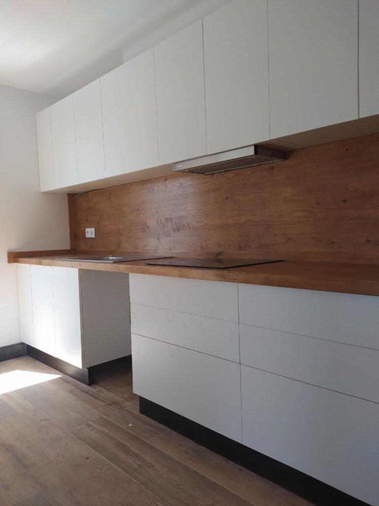 Cocina moderna con muebles blancos en casa prefabricada de madera en Port del Comte