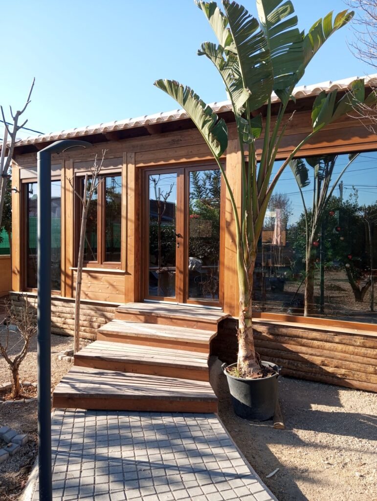 Entrada de casa prefabricada diáfana de madera en Murcia con grandes ventanales y acceso elevado