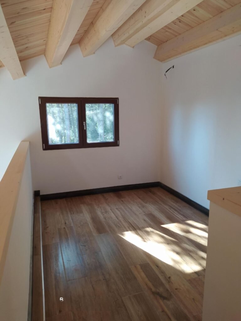 Altillo con vigas de madera vistas en casa prefabricada de madera en Port del Comte