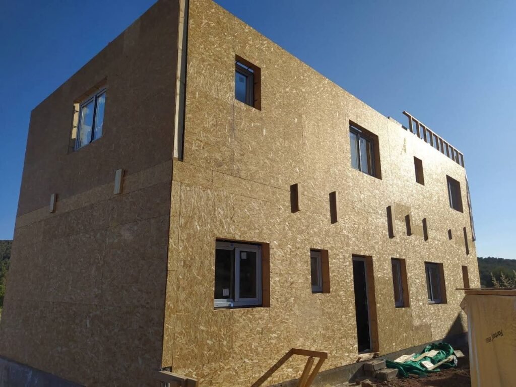 Estructura de casa prefabricada cerrada con paneles OSB durante el montaje en obra