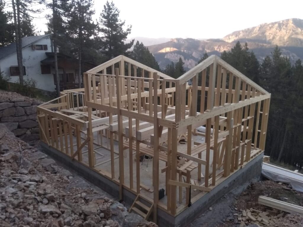 Estructura de entramado de madera de casa prefabricada en fase de montaje sobre cimentación