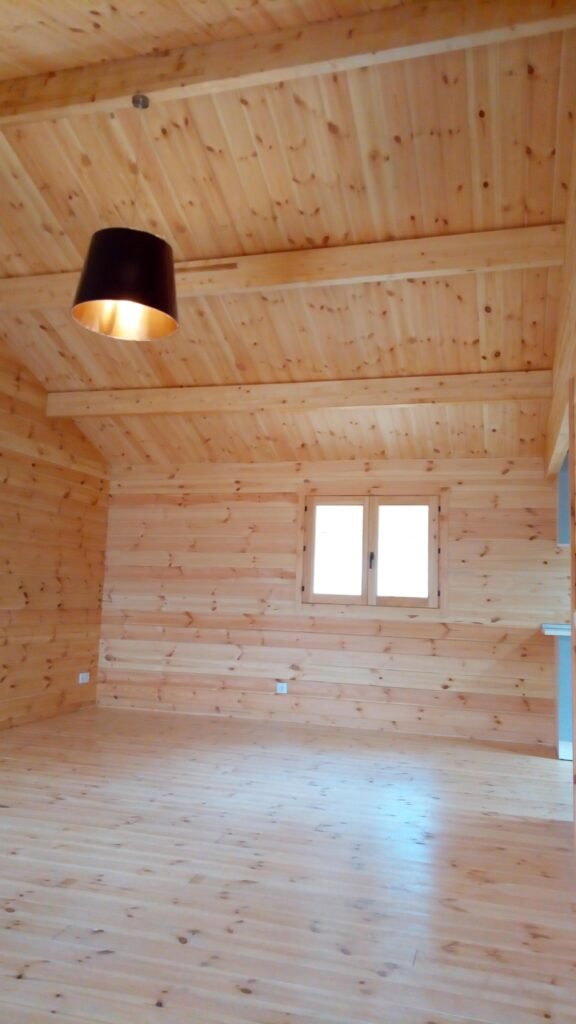 Salón diáfano con acabados de madera en casa prefabricada en Sagunto