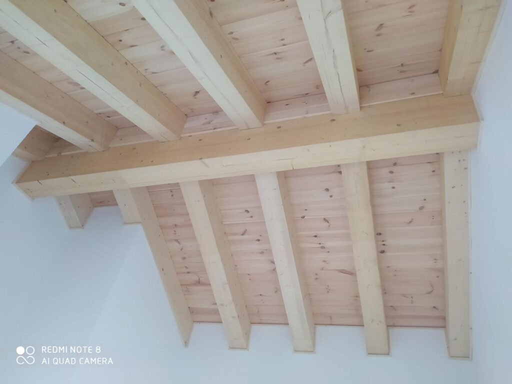 Techo interior con vigas de madera vistas en casa prefabricada de madera en Port del Comte